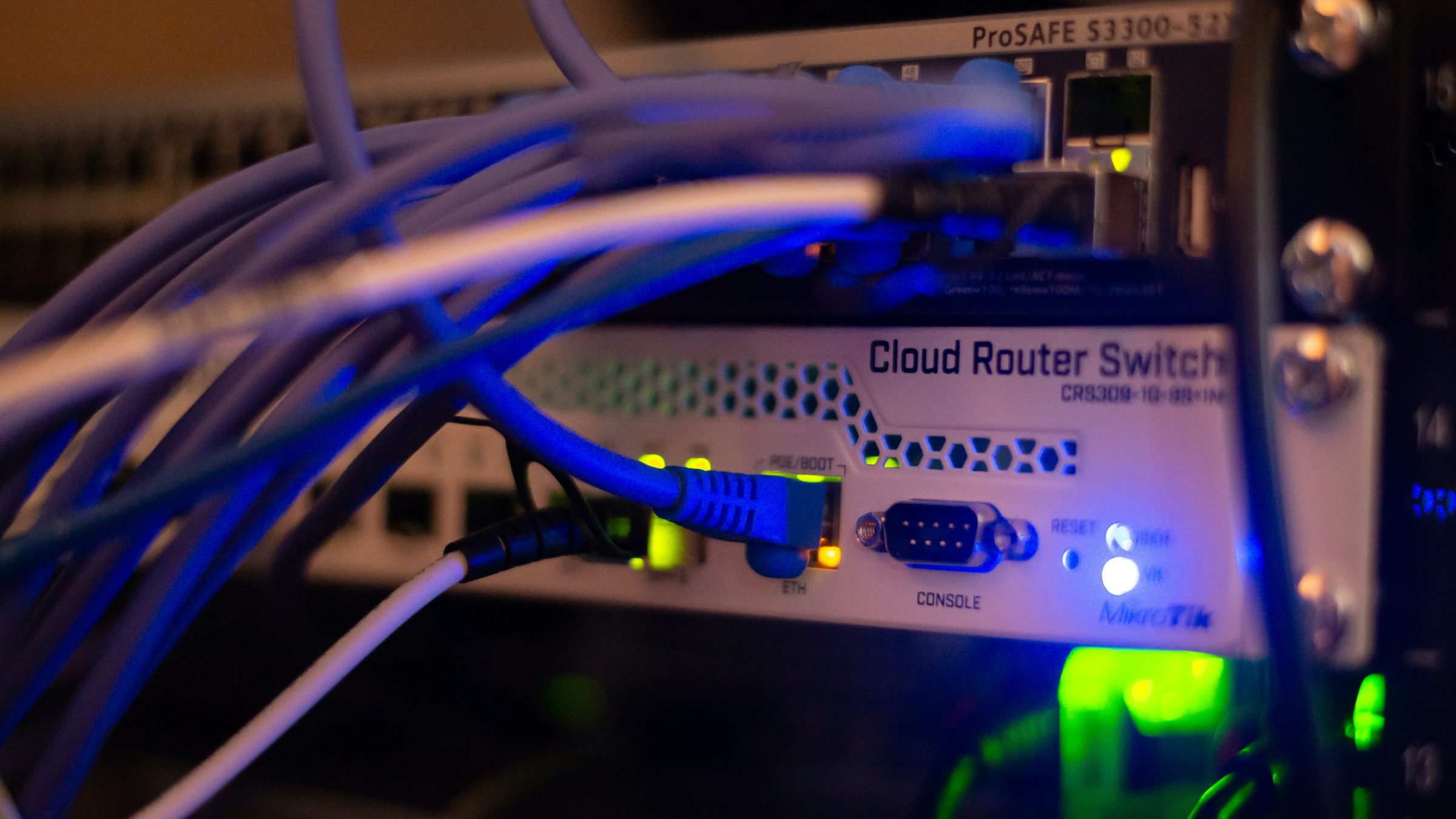Switch de red en un rack con cables conectados y luces indicadoras encendidas